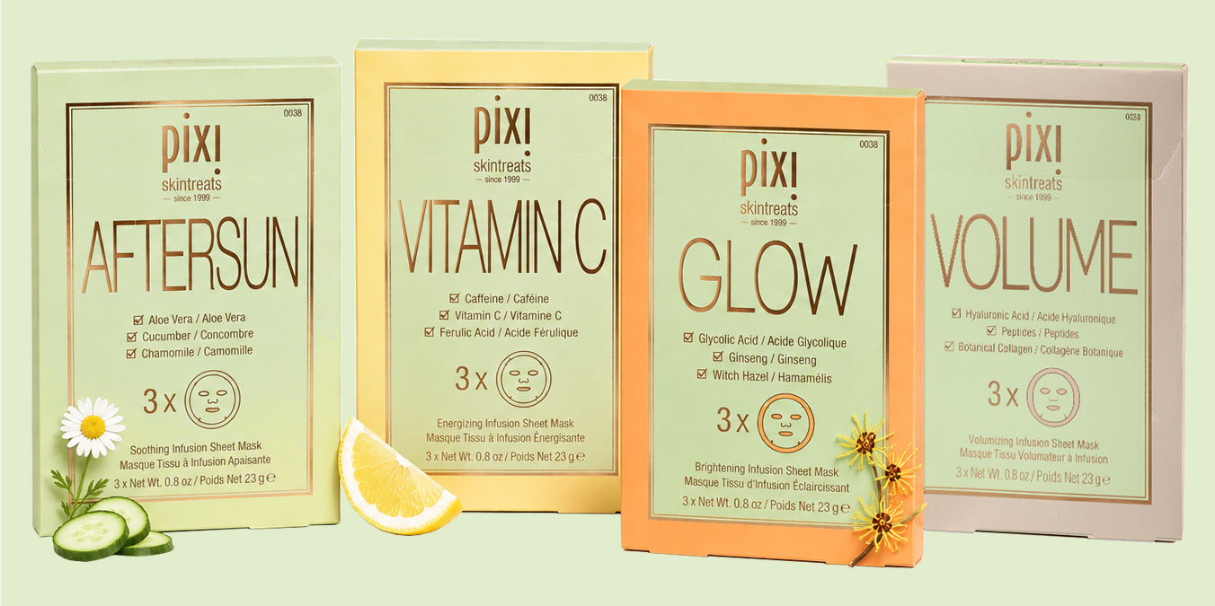 Four Pixi skincare sheet mask packets arranged side by side on a pale green background, with decorative food props including a daisy, cucumber slices, and a lemon wedge. The packets are labeled Aftersun, Vitamin C, Glow, and Volume. View 2